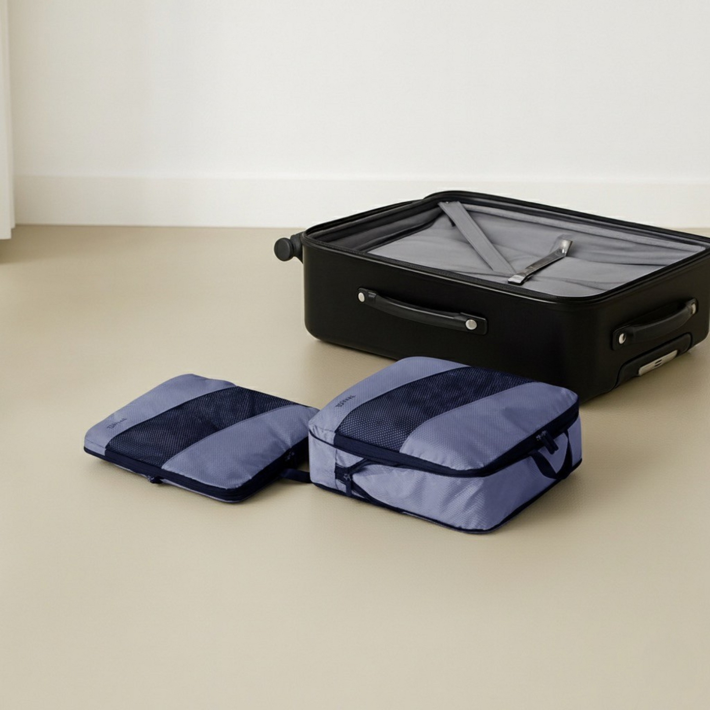 Two purple packing cubes next to suitcase